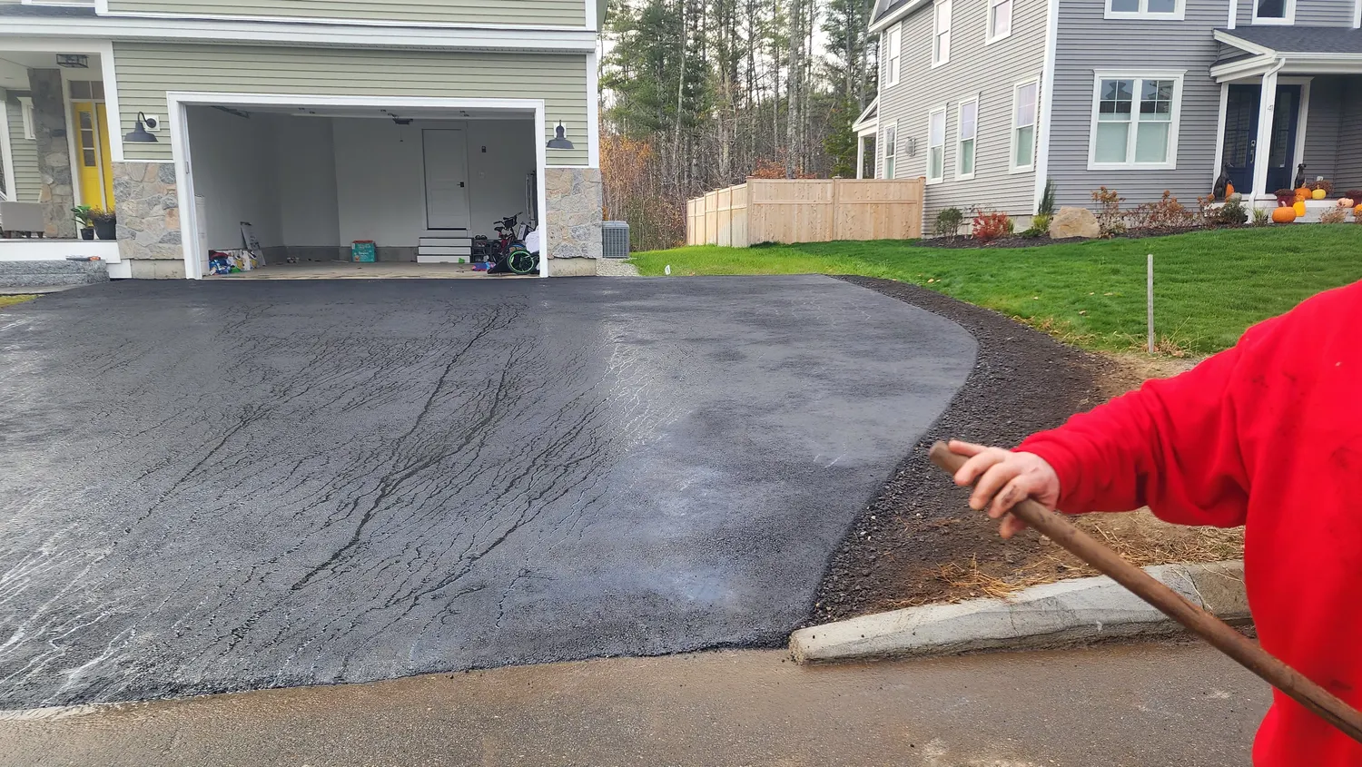 Crew finishing a new asphalt apron by hand