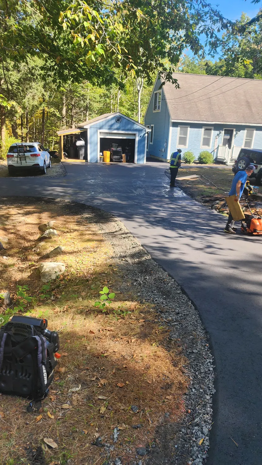 Hand raking fresh hot asphalt on a new driveway