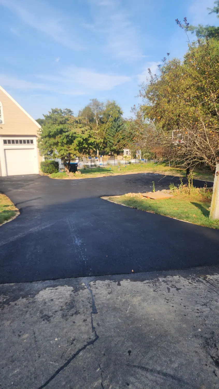 Smooth sealcoated driveway curving through the trees