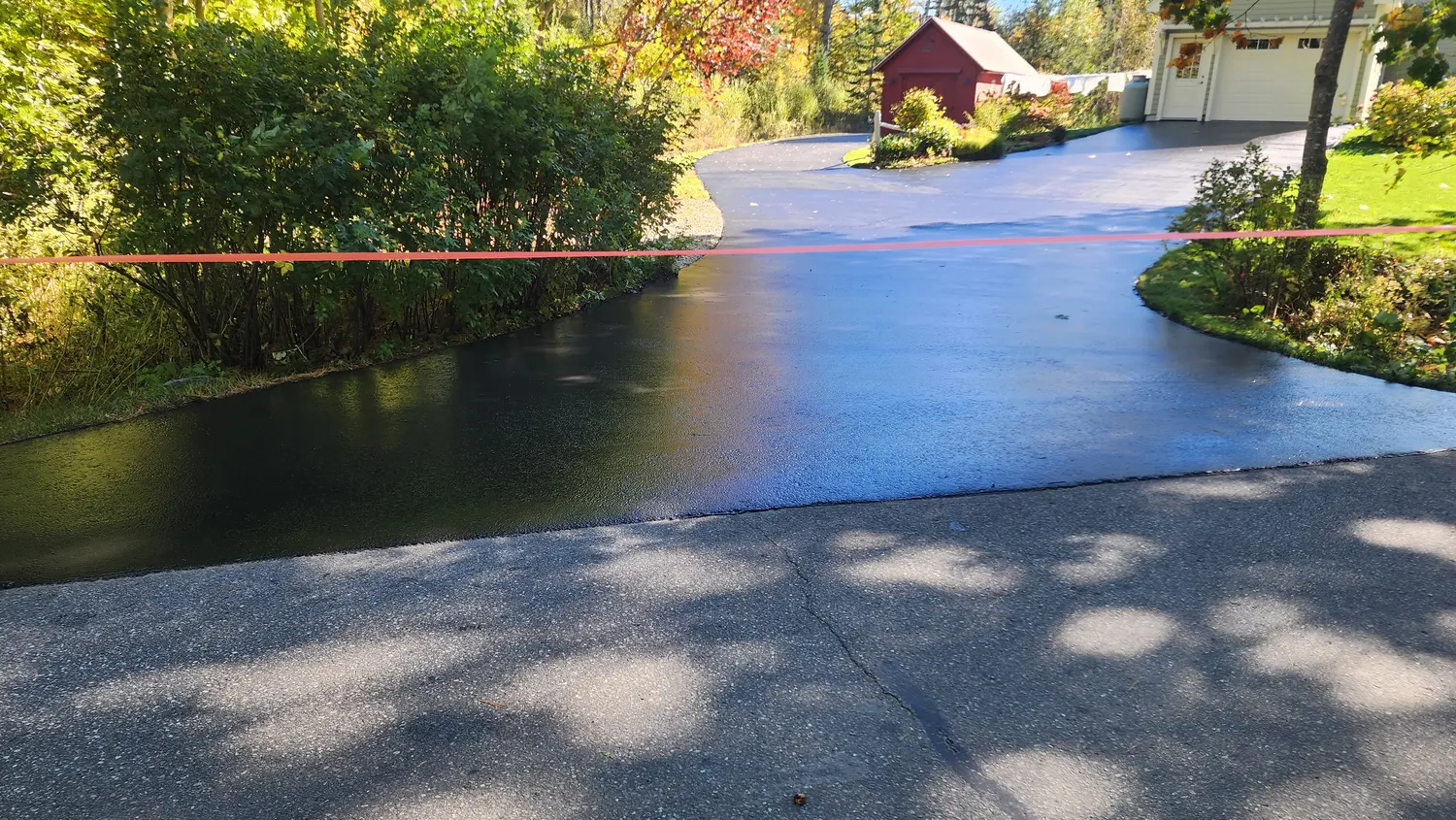 Freshly sealcoated residential driveway with a wet black finish